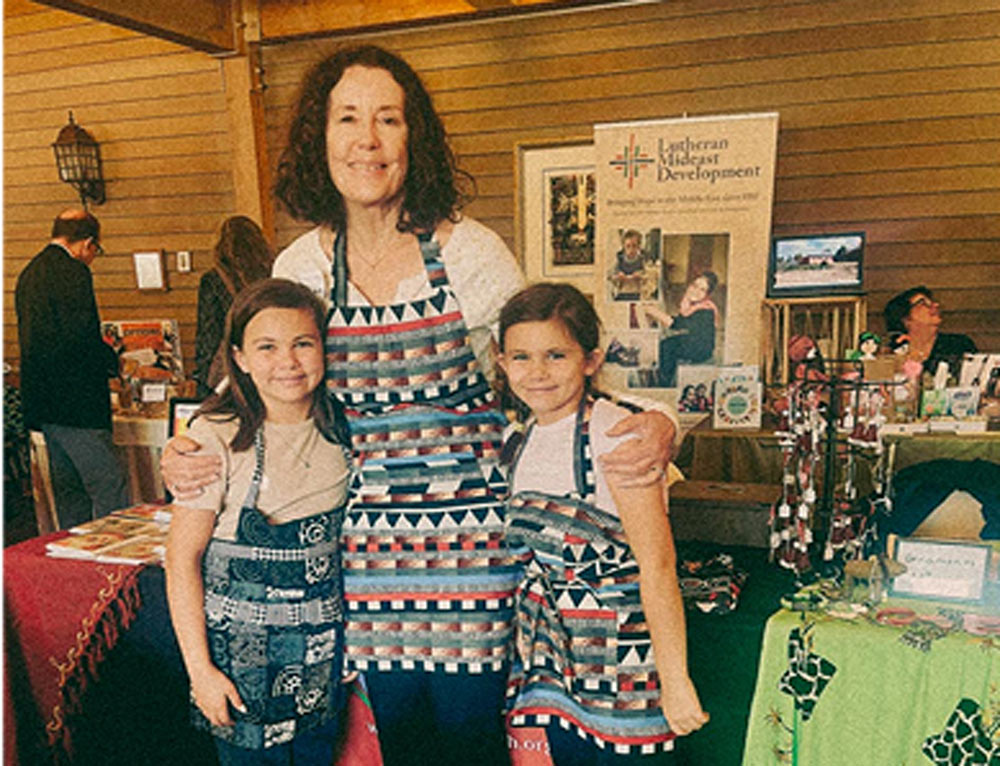 Donors wearing custom made apron from a KYCC entreprenuer